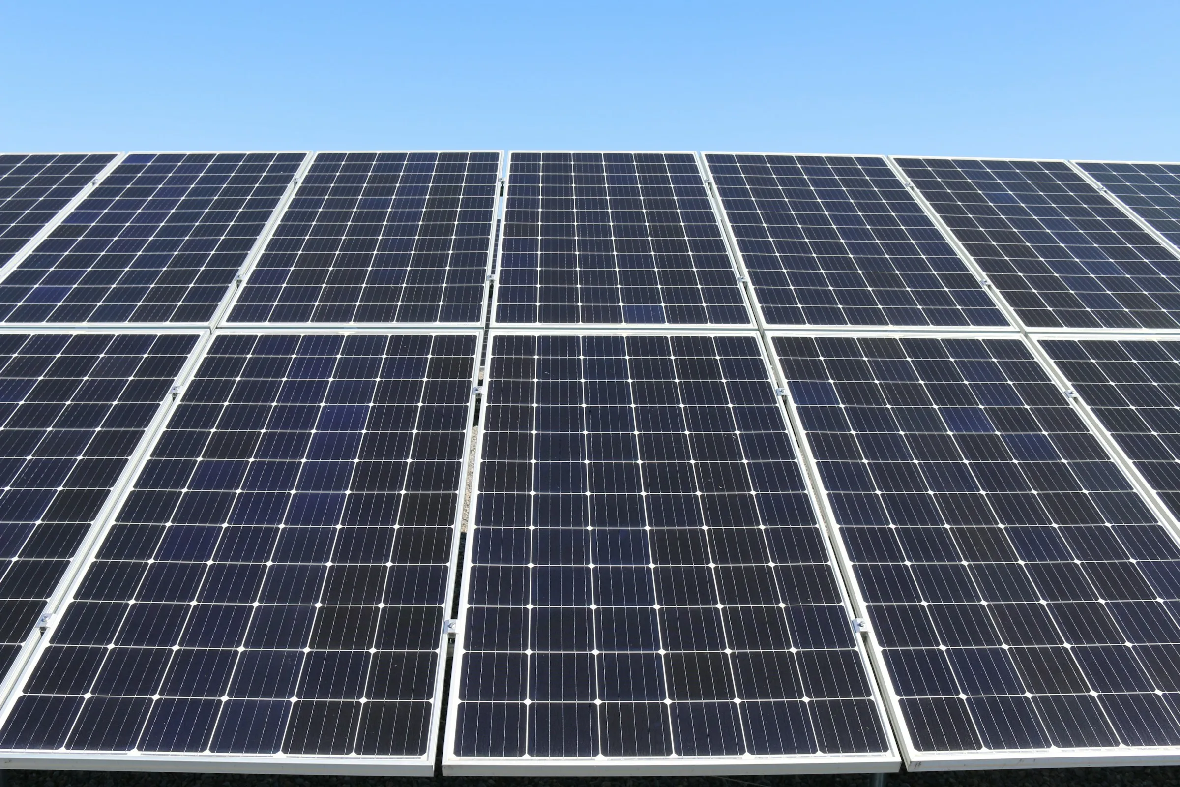 Rows of monocrystalline solar panels under a clear sky